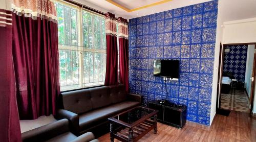 a living room with blue and red walls and a couch at Hosamane Farm Inn in Sringeri