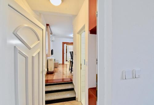 a hallway with a white door and a staircase at Lovely apartment few minutes from the beach in Štinjan