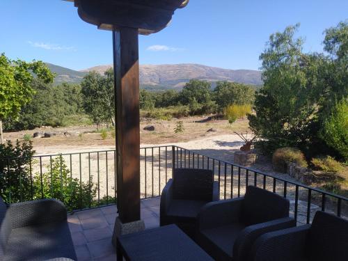 a balcony with chairs and a view of a river at Pago de Yuste - Casa Rural Apartamentos in Cuacos de Yuste