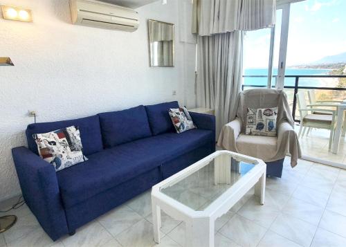 un sofá azul y una silla en la sala de estar en Skol 701. One Bedroom Duplex with Exceptional Sea Views., en Marbella