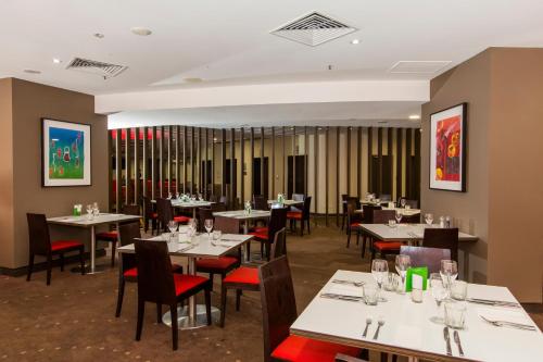 a dining room with tables and chairs in a restaurant at Hotel Grand Chancellor Townsville in Townsville