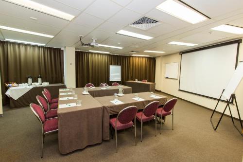 a conference room with a table and chairs and a whiteboard at Hotel Grand Chancellor Townsville in Townsville