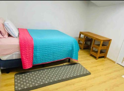 - une chambre avec un lit, une table et un tapis dans l'établissement Departamento Magnolia, 5 min AEROPUERTO, à Nextetelco