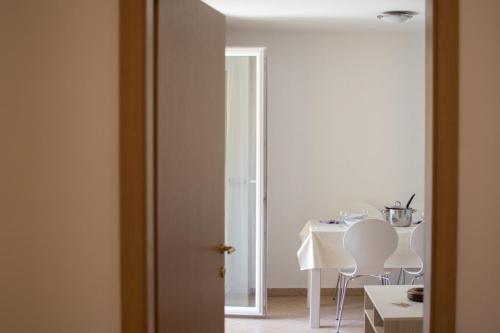 Zimmer mit einem Tisch und Stühlen sowie einem weißen Tisch und Stühlen in der Unterkunft Apartments Faro in Bašanija