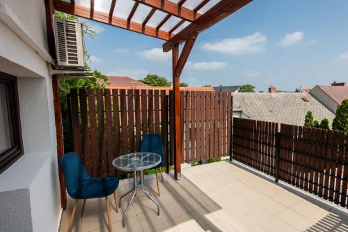 a patio with two chairs and a table and a fence at Fényes Vinorium in Sopron