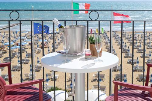 a table on a balcony with a view of the beach at Hotel Manila in Lido di Jesolo