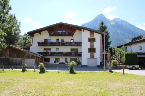 a large white building with mountains in the background at Haus Maria Larcher in Bach