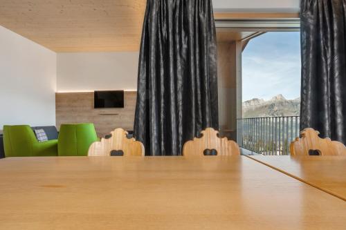 a conference room with a table and green chairs at Ferienwohnungen Tannenboden in Flumserberg