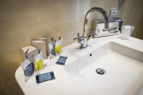 a bathroom sink with toothbrushes and soap at Hotel Villa La Principessa in Lucca