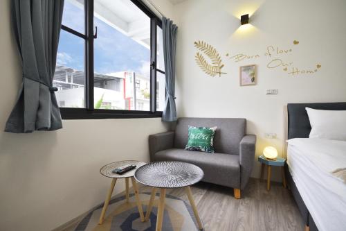 a bedroom with a bed and a chair and a window at Full house in Taitung City