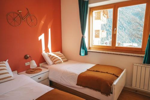 a bedroom with two beds and a bike on the wall at Casa di Franz in Vigo di Fassa