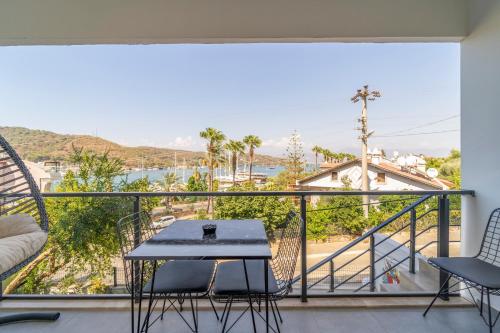 a balcony with a table and chairs and a view at Nakas Suites in Fethiye
