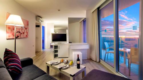 a living room with a couch and a tv at Le Bleu Hotel & Resort Kusadasi in Kusadası