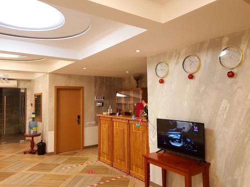 - un salon avec une télévision et des horloges murales dans l'établissement Happy Inn Hotel Alpiyskiy, à Saint-Pétersbourg