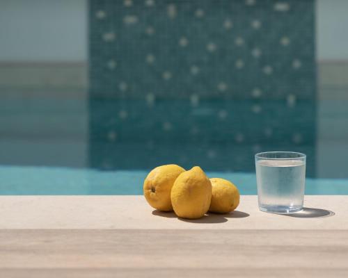 eine Gruppe Zitronen auf einem Tisch mit einem Glas Wasser in der Unterkunft De Light Boutique Villas I II & III - Fine retreat, by ThinkVilla in Atsipopoulo