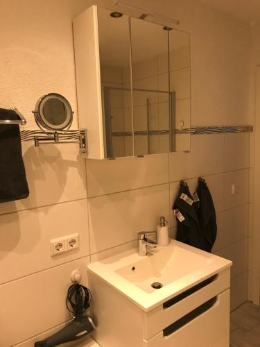 バート・ハルツブルクにあるFewo Tiewesのバスルーム(白い洗面台、鏡付)