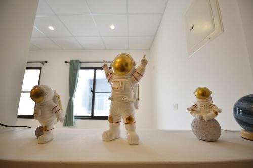 a group of three toy astronauts standing on a shelf at Full house in Taitung City