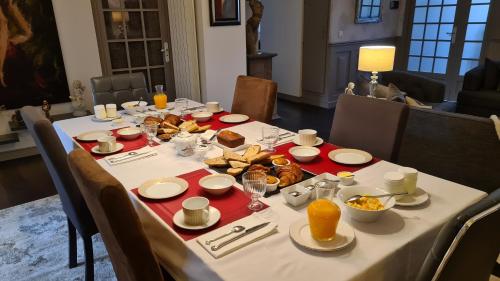 een tafel met een witte tafeldoek met voedsel erop bij La Glycine Blanche in Pomas