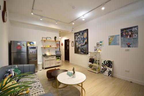 a living room with a table and a kitchen at Full house in Taitung City