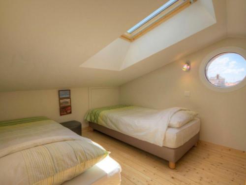 Schlafzimmer im Dachgeschoss mit 2 Betten und einem Fenster in der Unterkunft Gîte La Chapelle-Basse-Mer, 3 pièces, 6 personnes - FR-1-306-814 in La Chapelle-Basse-Mer