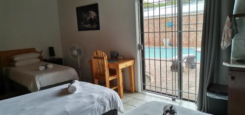 伊麗莎白港的住宿－The Bay Inn，一间带两张床的卧室和一个带游泳池的阳台