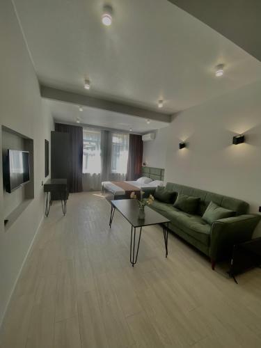 a living room with a green couch and a table at Апарт-отель Nine Rooms in Yerevan