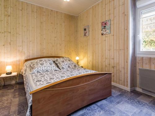 1 dormitorio con 1 cama en una habitación con paredes de madera en Gîte Frossay, 2 pièces, 2 personnes - FR-1-306-1027, en Frossay