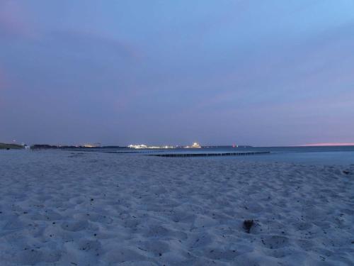 ヴァーネミュンデにあるFerienwohnungen seaZEIT Objektの遠くに桟橋がある砂浜