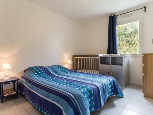 een slaapkamer met een bed met een blauwe deken en een raam bij Gîte Nozay, 4 pièces, 6 personnes - FR-1-306-1178 in Nozay