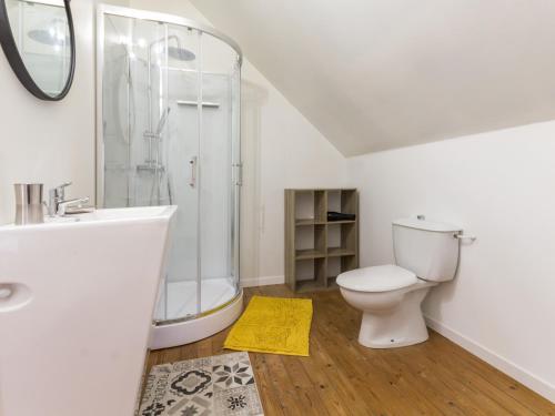 een witte badkamer met een douche en een toilet bij Gîte Saint-Lyphard, 3 pièces, 5 personnes - FR-1-306-941 in Saint-Lyphard