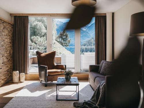 a living room with a couch and chairs and a large window at VAYA Terrazena Serfaus inklusive Super Sommer Card in Serfaus