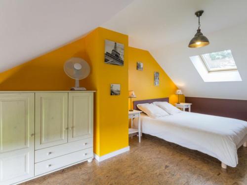 - une chambre avec un lit blanc et un mur jaune dans l'établissement Gîte Nort-sur-Erdre, 3 pièces, 5 personnes - FR-1-306-1145, à Nort-sur-Erdre