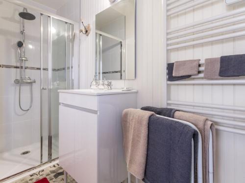 ein Bad mit einem Waschbecken, einer Dusche und Handtüchern in der Unterkunft Gîte Saint-Lyphard, 3 pièces, 4 personnes - FR-1-306-1163 in Saint-Lyphard