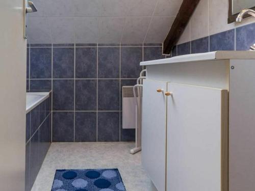 uma casa de banho com um frigorífico branco e azulejos azuis em Gîte Mesquer, 4 pièces, 5 personnes - FR-1-306-1068 em Mesquer