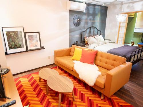 a living room with a couch and a bed at Tsubame Hotel Asakusabashi 3 minutes walk from Asakusabashi Station Near Asakusa, Akihabara, and Ueno Cooking utensils and kitchen washing machine available Direct access to Haneda and Narita airports in Tokyo