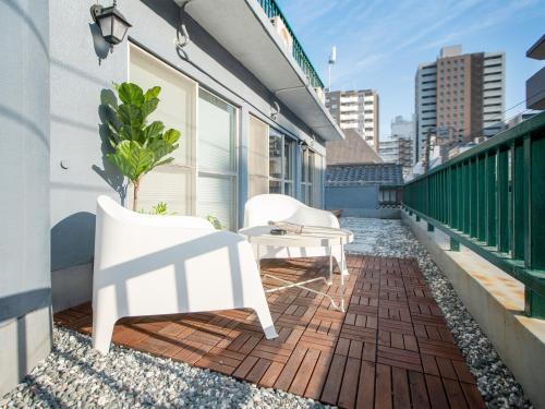 a balcony with two chairs and a table on a building at Tsubame Hotel Asakusabashi 3 minutes walk from Asakusabashi Station Near Asakusa, Akihabara, and Ueno Cooking utensils and kitchen washing machine available Direct access to Haneda and Narita airports in Tokyo