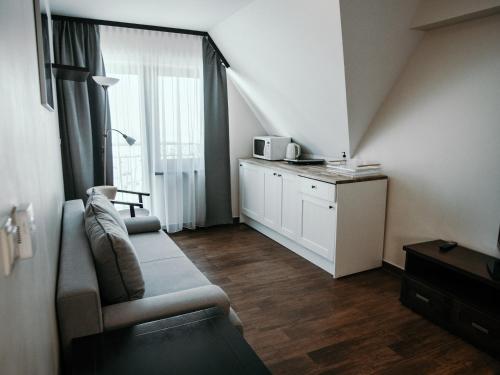 a living room with a couch and a window at Willa Pachówka - tam, gdzie natura spotyka się z nowoczesnością in Bukowina Tatrzańska