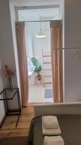 a bedroom with a bed and a bathroom with a tub at Tiny suite with private bathroom - Bairro Alto in Lisbon