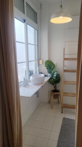 a bathroom with a sink and a window at Tiny suite with private bathroom - Bairro Alto in Lisbon