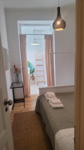 a bedroom with a bed with two towels on it at Tiny suite with private bathroom - Bairro Alto in Lisbon