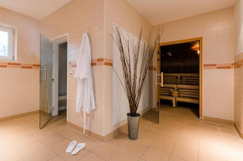 a bathroom with a potted plant and white shoes at Ferienpark Plauer See in Alt Schwerin