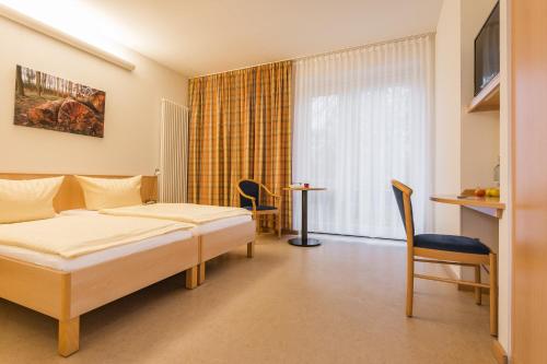 Habitación de hotel con cama, mesa y sillas en Ferienpark Plauer See, en Alt Schwerin