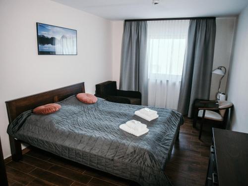 a bedroom with a bed with two towels on it at Willa Pachówka - tam, gdzie natura spotyka się z nowoczesnością in Bukowina Tatrzańska