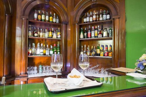 a bar with two wine glasses on a table at Hotel Villa La Principessa in Lucca