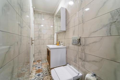 a white bathroom with a toilet and a shower at Nakas Suites in Fethiye