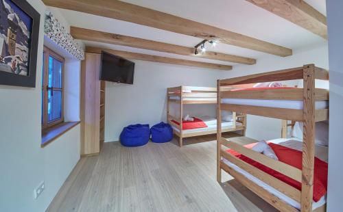 a room with two bunk beds and a flat screen tv at Chalet Tannenbaum in Saalbach Hinterglemm