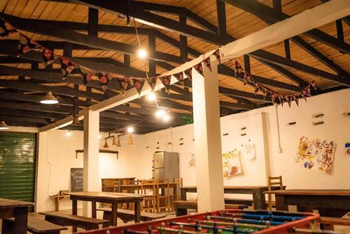 a large room with wooden tables and chairs and flags at Granja La Lechuza Ecolodge in Oberá