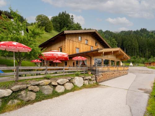 a wooden building with red umbrellas in front of it at Apartment Talbach by Interhome in Laimach
