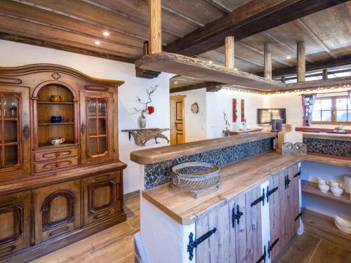 eine große Küche mit Holzschränken und einer Holzdecke in der Unterkunft Chalet Aualm - FRT100 by Interhome in Forstau