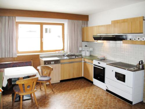 eine Küche mit einem Tisch und einem weißen Herd mit Backofen in der Unterkunft Holiday Home Waldhof - SOE685 by Interhome in Im Brand